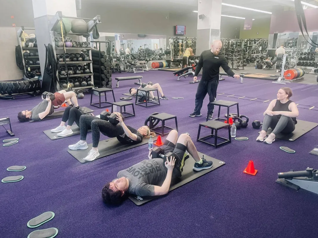 Trainer coaching members through a floor workout in one of our gyms